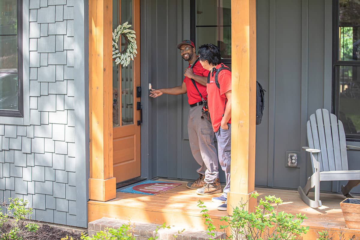Two Super Cool Air Conditioning & Heating workers ringing a doorbell