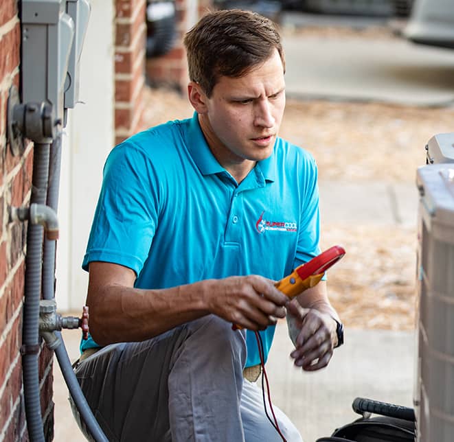 Super Cool Air Conditioning & Heating worker doing maintenance on an HVAC unit