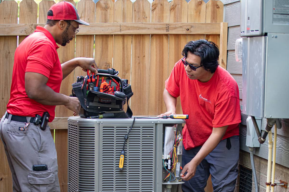 two Super Cool Air Conditioning & Heating workers installing an hvac unit