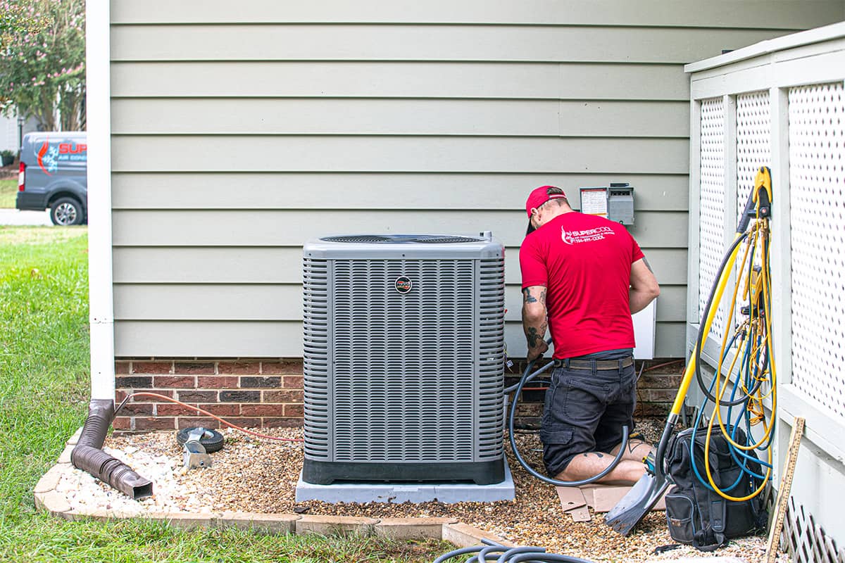 Super Cool Air Conditioning & Heating employee working on a heat pump